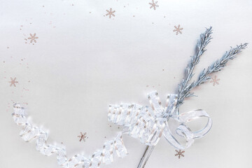 Celebration of Christmas and new year winter holidays, banner with copy space for text. Festive greeting card with silver twigs tied with lace ribbon bow, snowflake glitter, invitation background