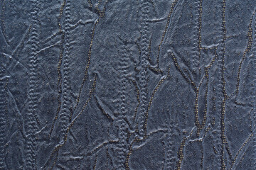 Black, artificial, ribbed, fluted leather on surface. Background or texture for design.