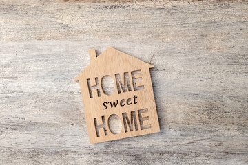 house modell with Home sweet Home inscription on wooden background