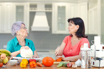 A caring daughter or volunteer regularly visits her old mother or customer to make a vegetable salad jointly. It is very important to pay attention to elderly people.