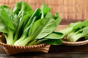 Fresh Bok Choy or Pak Choi(Chinese cabbage) in bamboo basket on wooden background, Organic vegetables