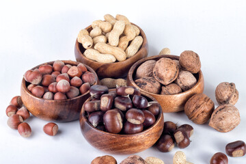 Shelled nuts in wooden stone, on white ground.