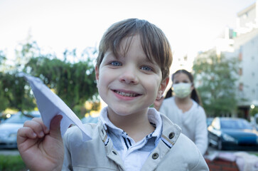 Children playing with paper airplane at urban park