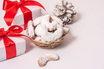 Traditional Austrian and German crescent-shaped Christmas pastries - Vanillekipferl - on a white table with Christmas decorations