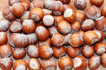 Hazelnuts lay evenly on a wooden surface. Close-up. Can be used as a natural background, texture.