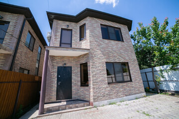 Exterior of a large two story brick residential home containing plenty of copy space,