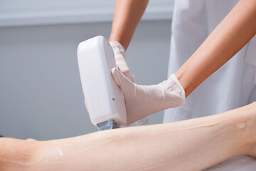 Picture of a young woman having laser hair removal procedure at salon .
