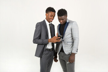 two handsome african men in suits with a mobile phone in their hands