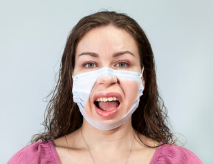 Irritation and disgust are on the face of an adult woman under medical mask with calm eyes....