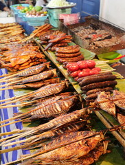 Grilled fish and meat skewers sold in an Asian food street market