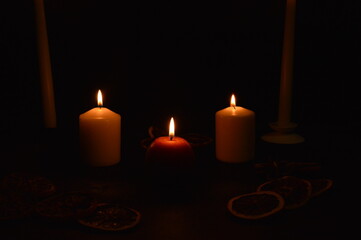 Group of burning candles on black background.