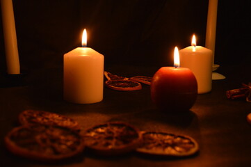 Group of burning candles on black background.
