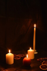 Group of burning candles on black background.