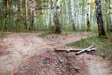 a wooden cross lost during the funeral is lying on the road