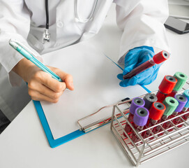 Scientists writing on chart and hold the blood tube from patient and research and analysis in a laboratory..