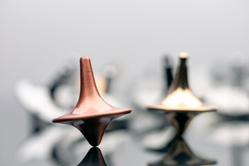 Beautiful copper spinning top spinning surrounded by many spinning tops