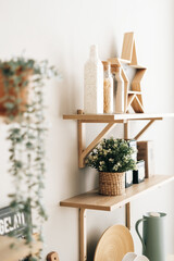 Grocery and kitchenware on the wooden shelves in modern bright kitchen.