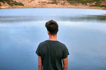 Young Caucasian man enjoying the lake view