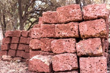 Traditional home-made bricks from red clay used to build houses in villages in Goa, India