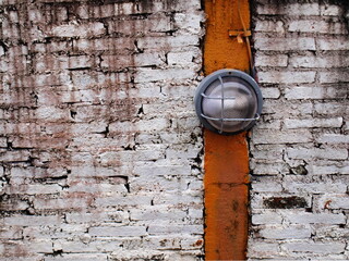 Antique lamp on an old brick wall. A vintage wall lamp for lighting up the night with a copy space. Close focus and choose a subject