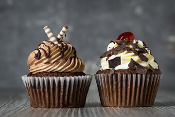 Chocolate and chocolate cherry cupcake side by side on a table for birthday party