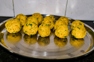 Indian Vegetarian koftas made with bottle gourd and gram flour as a main ingredients with onion, coriander leaf other ready for frying.
- 387812592