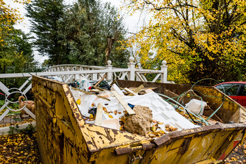 Filled yellow rubbish Skip seen located near a bridge leading to a nature reserve. The Skip is full...