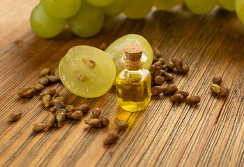 Grape Oil Seed in Small Vintage Bottle on Wooden Rustic Background