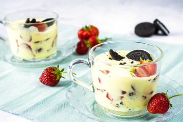Zabaglione with strawberries and chocolate cookies on a blue napkin - obrazy, fototapety, plakaty