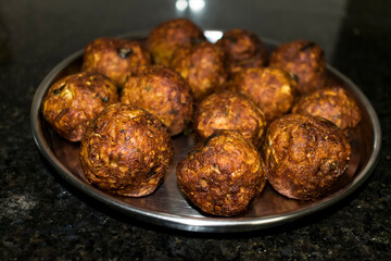  Indian Vegetarian koftas made with bottle gourd and gram flour as a main ingredients with onion, coriander leaf kept aside after deep frying.
- 387813989