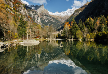 panorama view of small lake with reflections and multicolor woods, in autumn season lake in Val di Mello, Val Masino , Italy - lombardy.