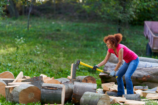 Woman farmer splitting wood logs