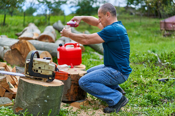 Lumberjack refilling his chainsaw