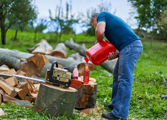 Lumberjack refilling his chainsaw