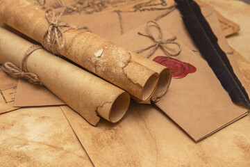 The surface of the old wooden table. On the table are old scrolls, an old map, an envelope with a...