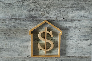 house modell with dollar sign on wooden background
