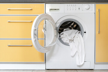 Modern washing machine stands in the kitchen