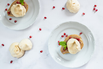 Roasted pears stuffed with pomegranate seeds, decorated with meringue