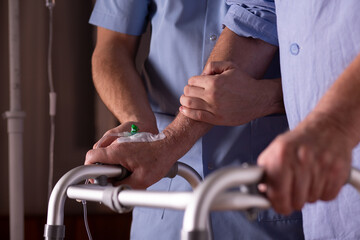 Closeup of senior man's hands holding walker, supporting male nurse at his site