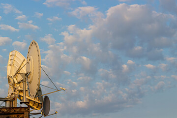 Satellite dish antenna against on cloudy sky background. Equipment for telecommunication
