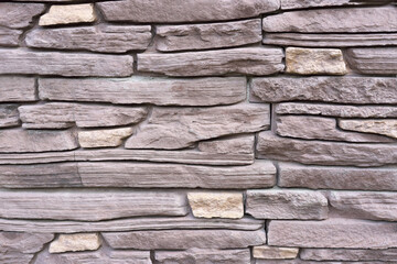 natural texture background, stone lined with granite walls. sandstone. stone background wall. Facing Stone in purple shades.