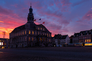 Fototapeta na wymiar Sky full of drama and amazing colors at the Market square and above the town hall in downtown Maastrichtof 