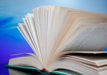 Pages of an unfolded book with a binding on a colorful background