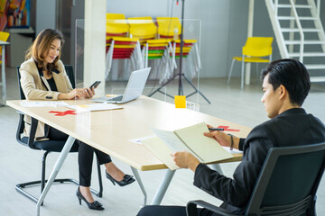 business man working apart from colleague  in the office. new normal social distancing concept.