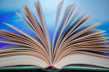 Pages of an unfolded book with a binding on a colorful background