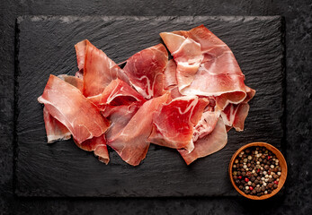 Spanish jamon Serrano, against a stone background	