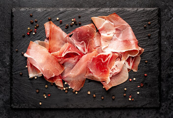 Spanish jamon Serrano, against a stone background	
