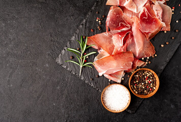 Spanish jamon Serrano, against a stone background with copy space