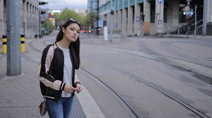 Fototapeta premium Young Asian woman waits for the tram in the city - urban photography