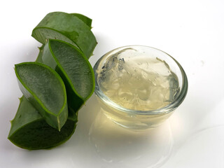Aloe vera herbs, sliced and cream on a cup, isolated on white background.
